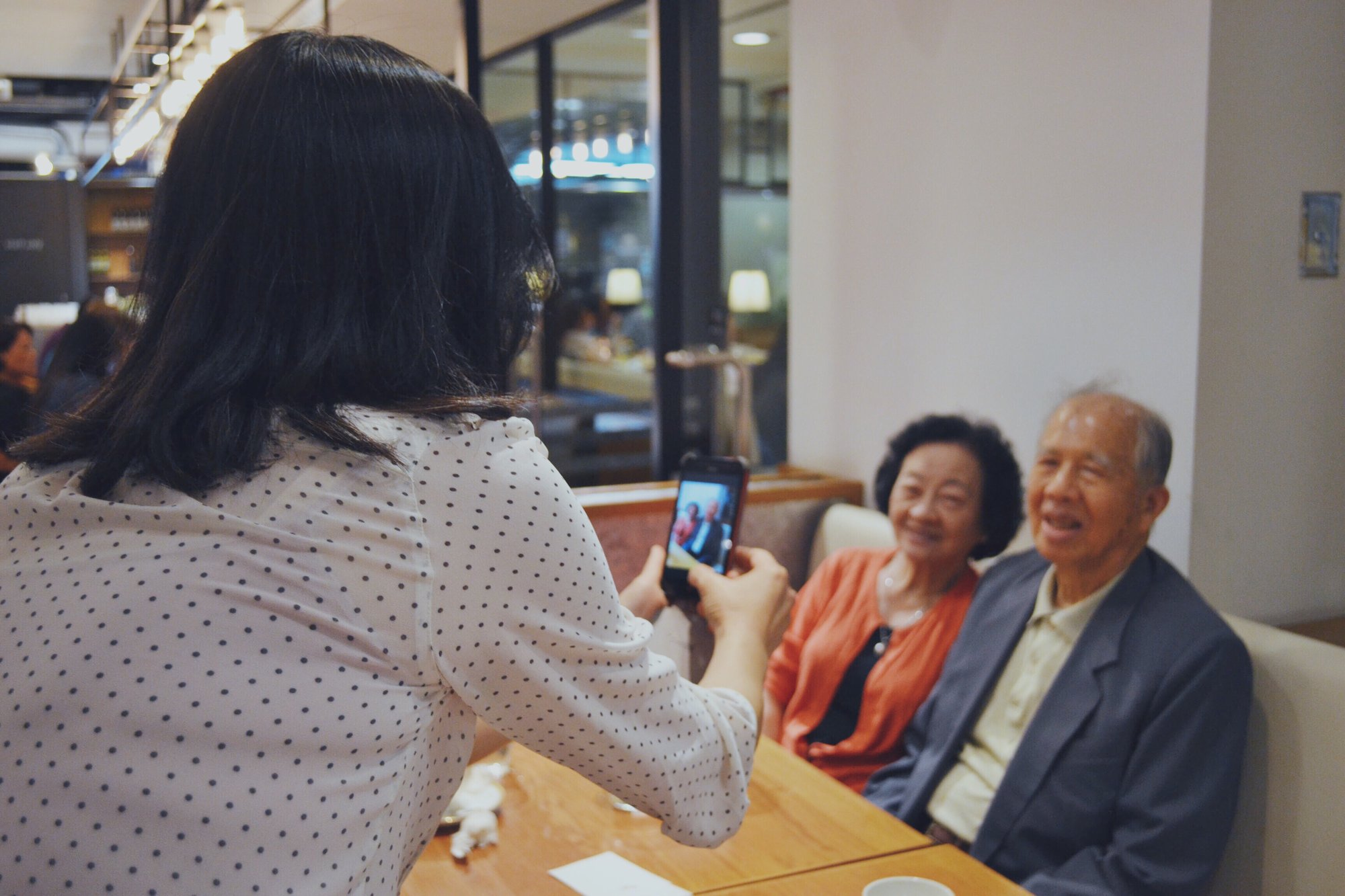adult_daughter_taking_picture_of_older_parents