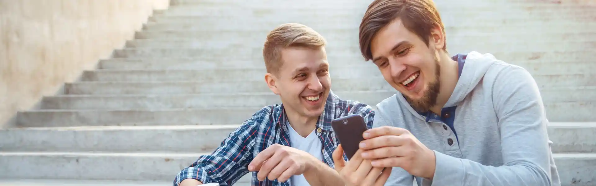 two-young-men-sitting-on-the-steps-and-laughing--looking